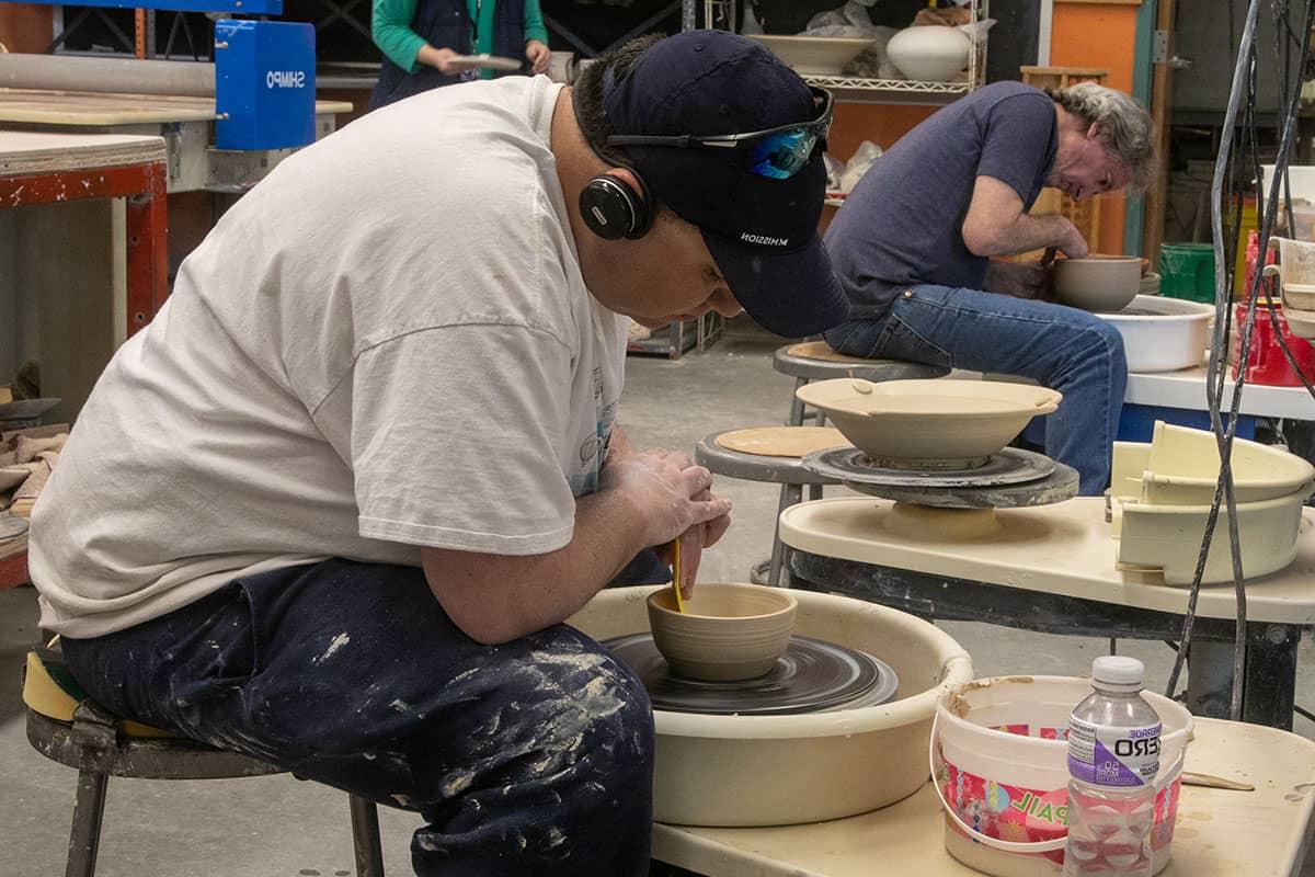 Student on the pottery wheel in the General Education Transfer Certificate Program